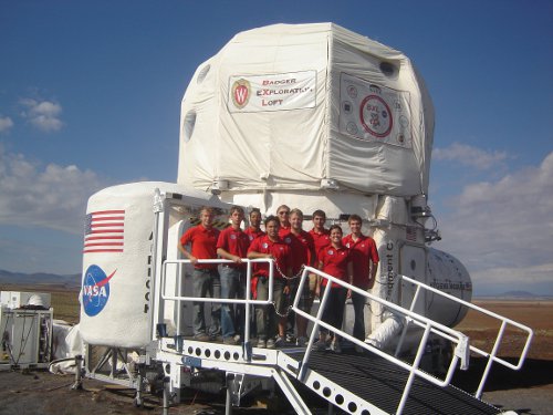The team poses in front of the habitat.